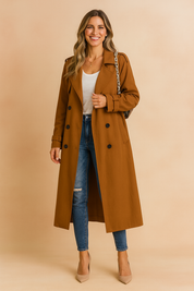 Camel double-breasted trench coat paired with a fitted white T-shirt, distressed blue skinny jeans, and beige pointed-toe pumps, accessorized with a gold pendant necklace and a chain-strap handbag.