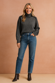 Charcoal gray turtleneck sweater with black piping details, paired with high-waisted medium-wash straight-leg jeans and dark brown ankle boots.