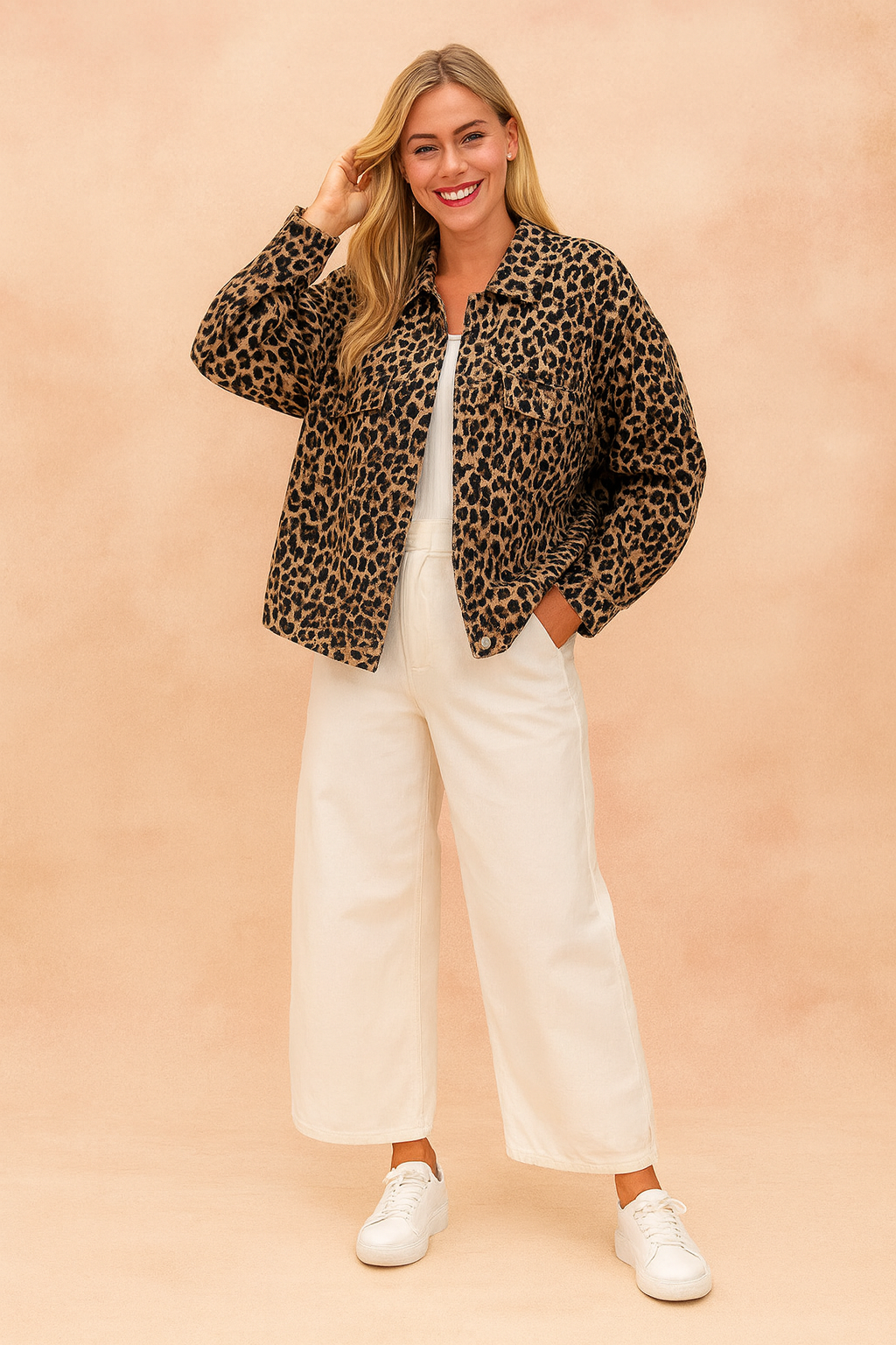 Leopard print button-up jacket with long sleeves, styled over a white top, paired with wide-leg cream trousers and white sneakers.