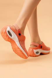 Coral orange breathable mesh slip-on clogs with air-cushioned midsoles, adjustable heel straps, and durable textured rubber outsoles.