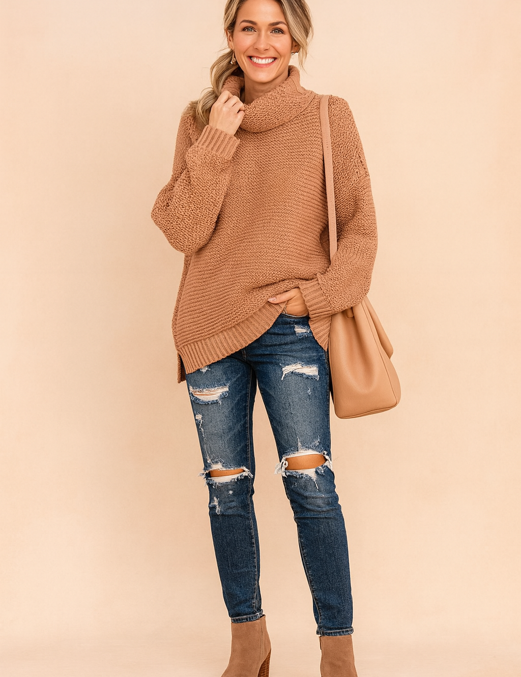Oversized camel knit turtleneck sweater with textured stitching, paired with distressed skinny blue jeans, taupe ankle boots, and a matching camel shoulder bag.