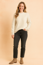 Cream ribbed knit sweater with a soft, fuzzy texture, paired with high-waisted charcoal jeans and taupe suede ankle boots.