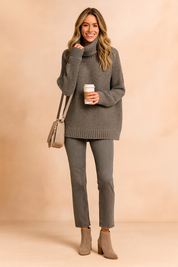 Chunky gray knit turtleneck sweater paired with slim gray jeans, taupe ankle boots, and a beige crossbody bag.