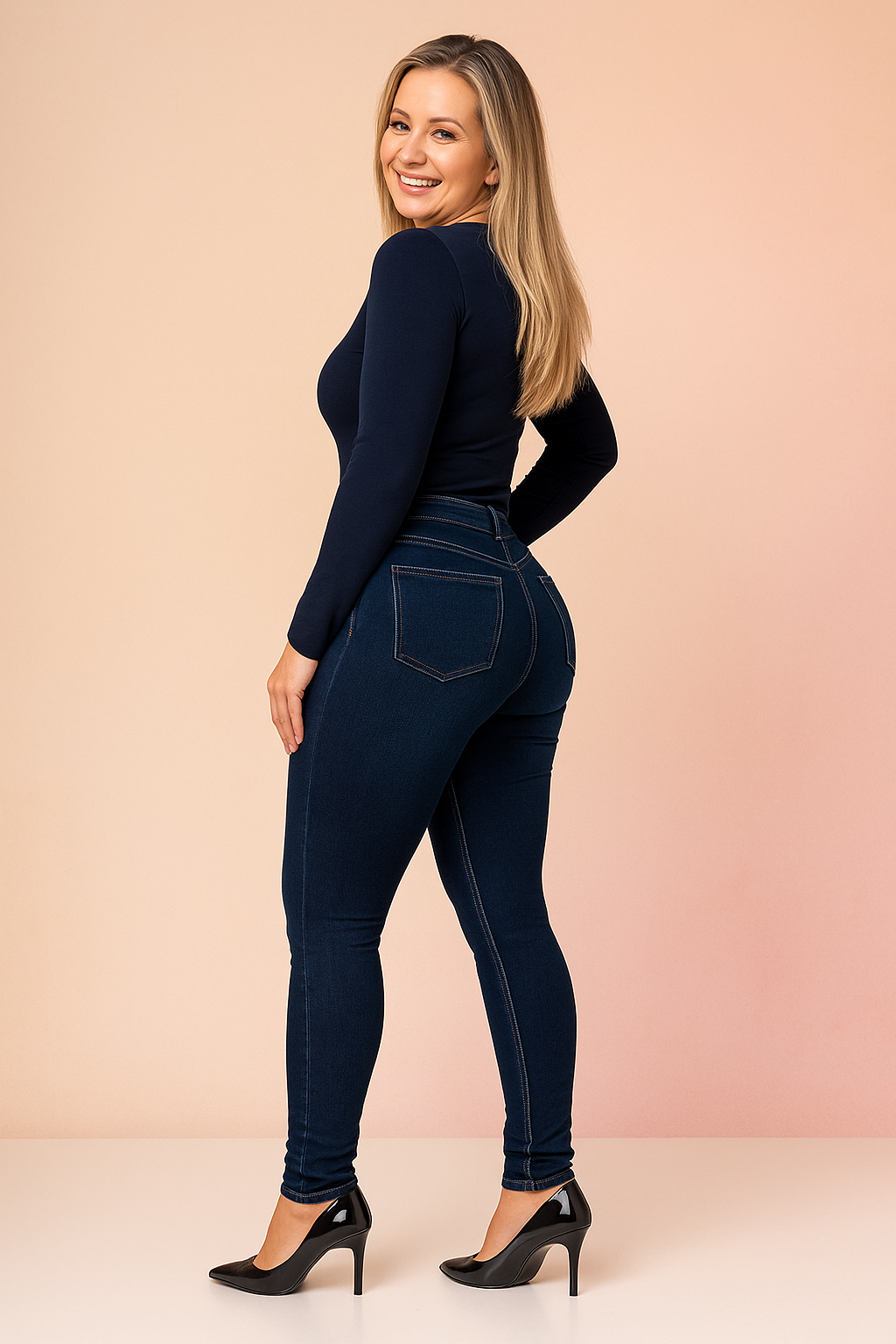 Dark blue skinny jeans with precise stitching, back pocket detail, and a fitted cut paired with black high heels.
