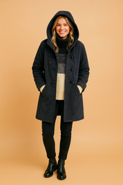 Dark gray hooded winter coat with toggle closures and front pockets, layered over a striped knit turtleneck sweater and paired with slim black pants and black ankle boots, emphasizing warmth and casual elegance