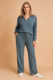 Dusty blue long-sleeve loungewear set featuring a V-neck top and matching wide-leg drawstring pants, made from soft knit fabric.