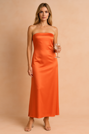 Elegancka sukienka maxi bez ramiączek w kolorze pomarańczowym z satynowym połyskiem, dopasowany krój podkreślający sylwetkę, idealna na wesele, przyjęcie lub wieczorne wyjście.