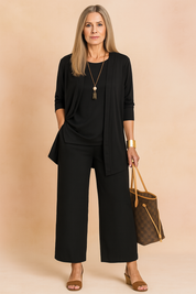Elegant black three-piece outfit featuring a relaxed-fit tunic top, open-front draped cardigan, and wide-leg ankle-length trousers in matching fabric.
