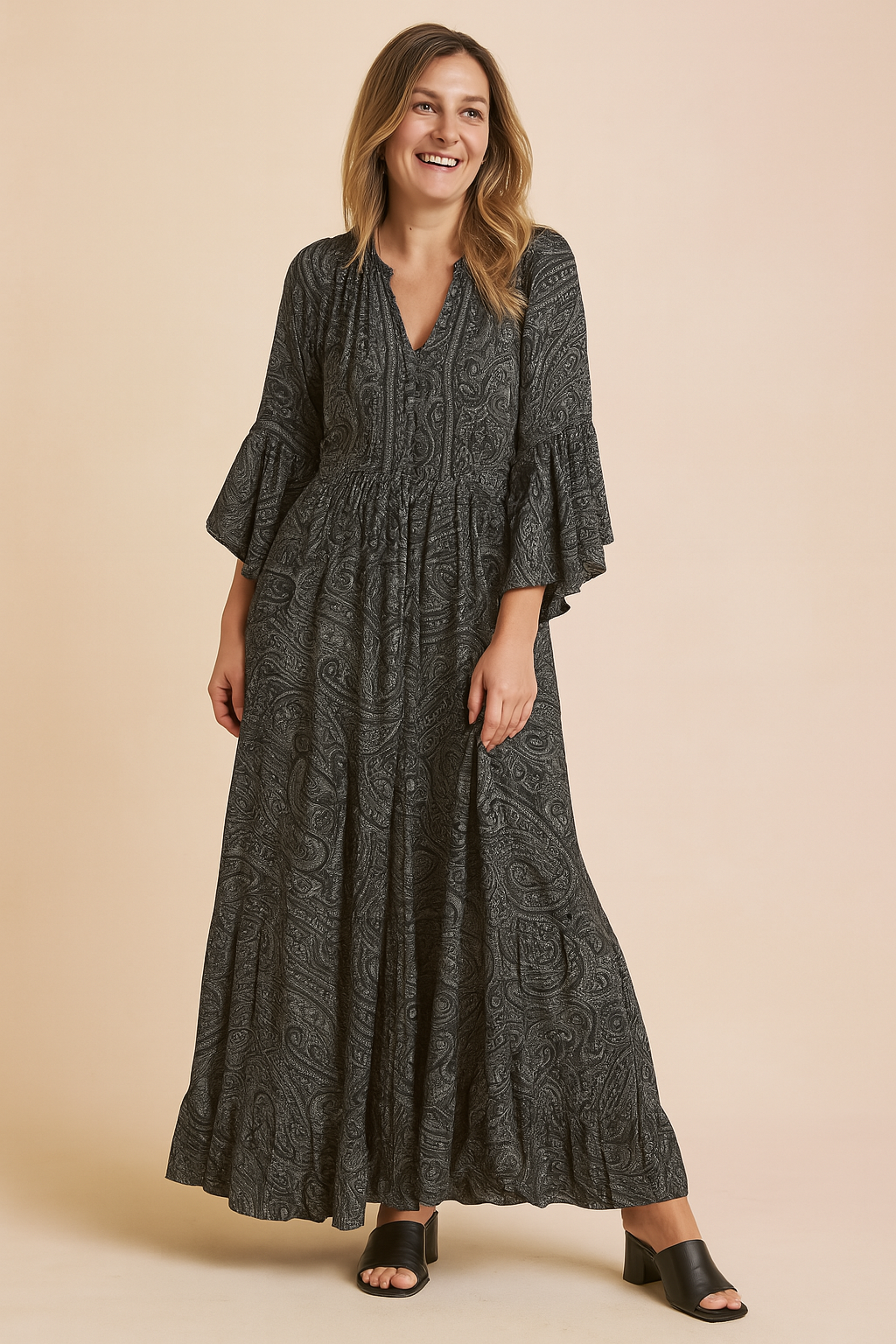 Long-sleeve charcoal paisley maxi dress with flared cuffs, V-neckline, tiered ruffle hem, and soft boho-inspired silhouette.