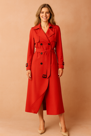  Elegant red double-breasted trench coat with black buttons, matching belt, structured lapels, and adjustable cuff straps, paired with beige pointed-toe heels.