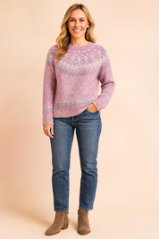 Dusty pink Fair Isle knit sweater with multicolor patterned yoke and hem, paired with medium-wash jeans and taupe suede ankle boots.