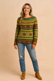 Green Fair Isle knit sweater with red and gold geometric patterns, front-tucked into mid-wash blue jeans, paired with tan suede ankle boots.