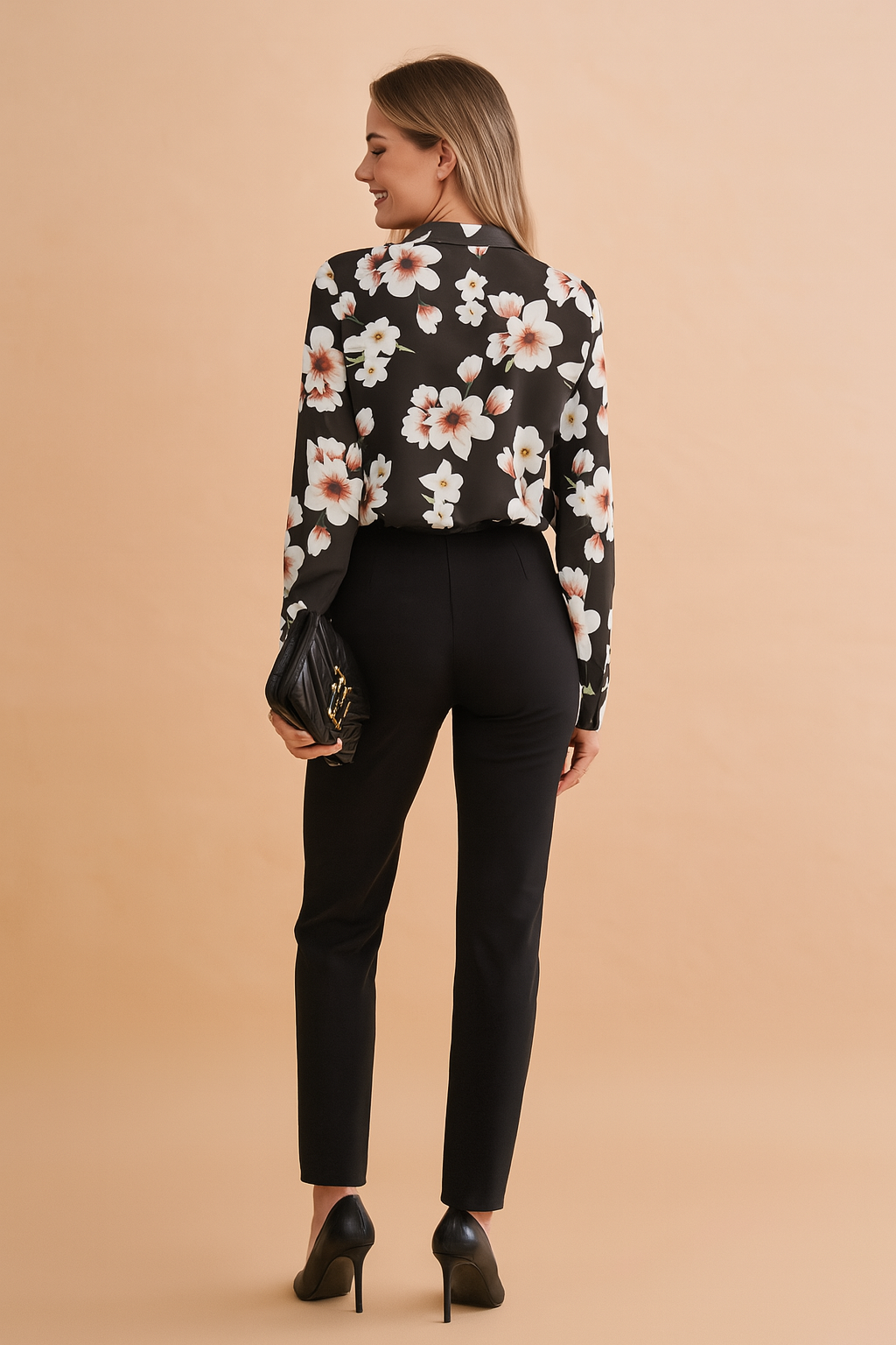 Black long-sleeve blouse with soft white and blush floral print, featuring a relaxed tailored fit and paired with sleek black high-waisted trousers.