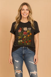 Women's charcoal graphic T-shirt with vivid multicolor botanical floral print, styled with distressed denim jeans.