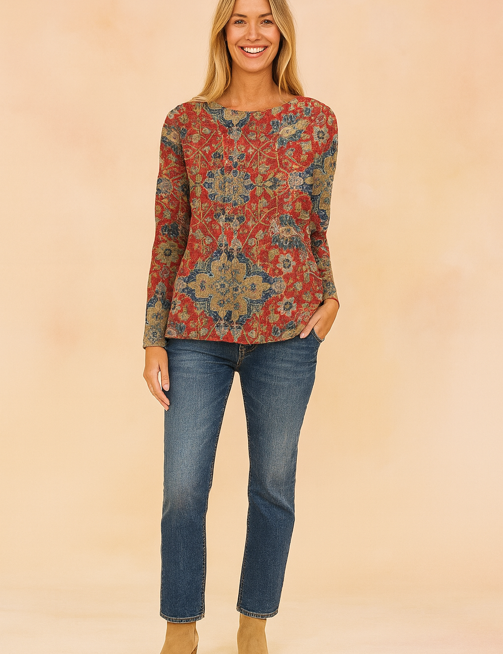 Long-sleeve sweater with an intricate red, blue, and beige floral tapestry pattern, paired with classic blue jeans and tan suede ankle boots.