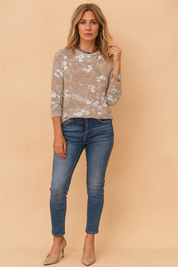 Long sleeve floral blouse with a soft vintage beige pattern paired with fitted denim jeans and nude heels, ideal for casual-chic styling.