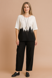  Two-piece forest-print casual outfit featuring a white half-sleeve top with black pine tree silhouette design and relaxed black ankle-length pants, styled with a vintage pendant necklace.