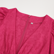 Close-up of a fuchsia jacquard mini dress with floral texture and back zipper detail.
