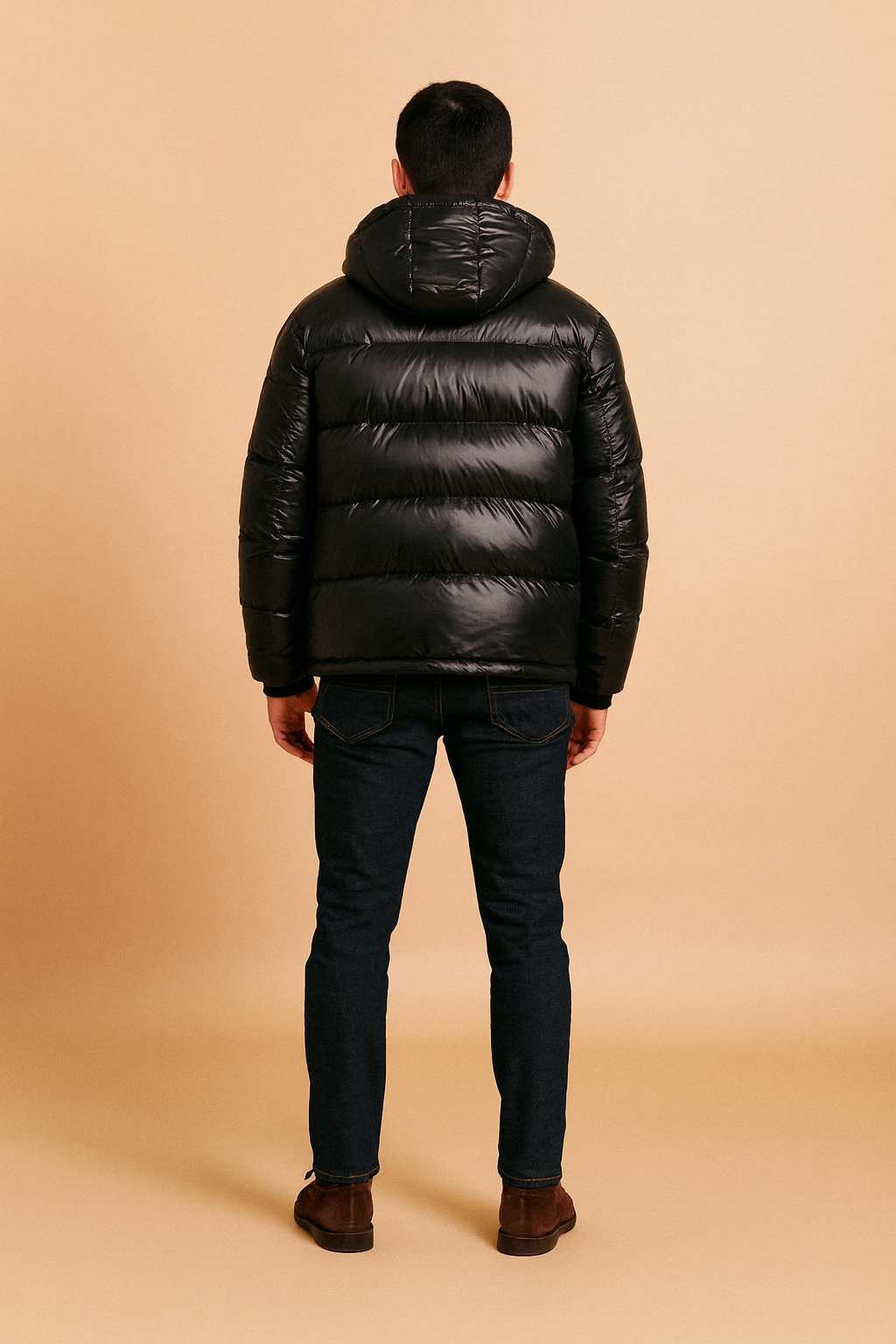 Back view of a glossy black puffer jacket with hood, horizontal quilted padding, and casual modern fit.
