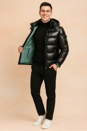 Glossy black puffer jacket with green lining, front zipper closure, padded sections, and hood, styled in a sleek casual fit.