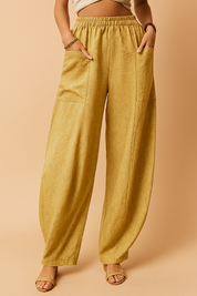 Golden yellow wide-leg linen pants featuring an elastic waistband, front patch pockets, and a subtle textured fabric with a soft, natural drape.