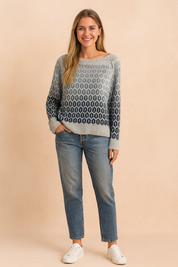 Grey to navy gradient knit sweater with oval geometric pattern, paired with mid-wash straight-leg jeans and white lace-up sneakers.