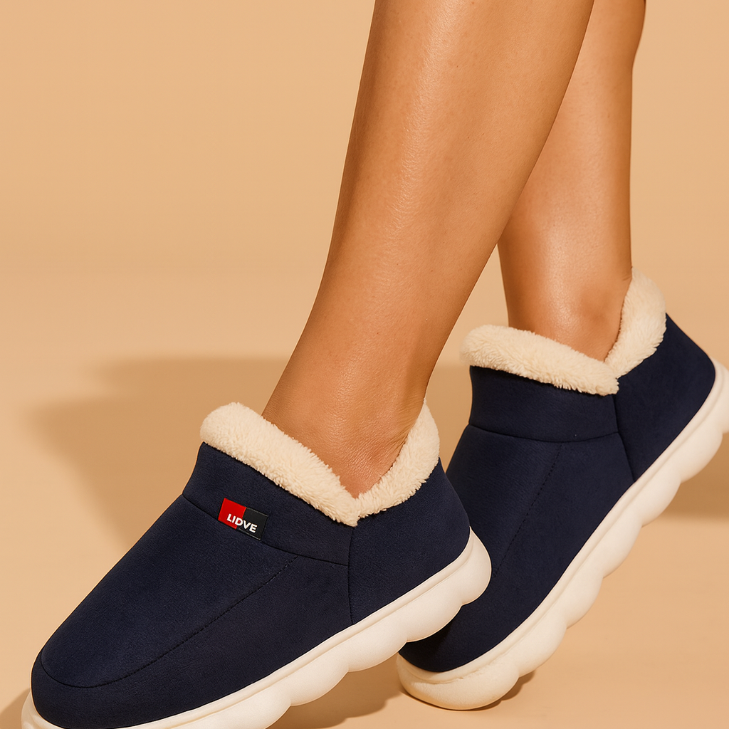 Granatowe kapcie domowe z miękką, kremową podszewką z futerka i białą podeszwą, zaprojektowane dla maksymalnego komfortu i ciepła w chłodne dni.