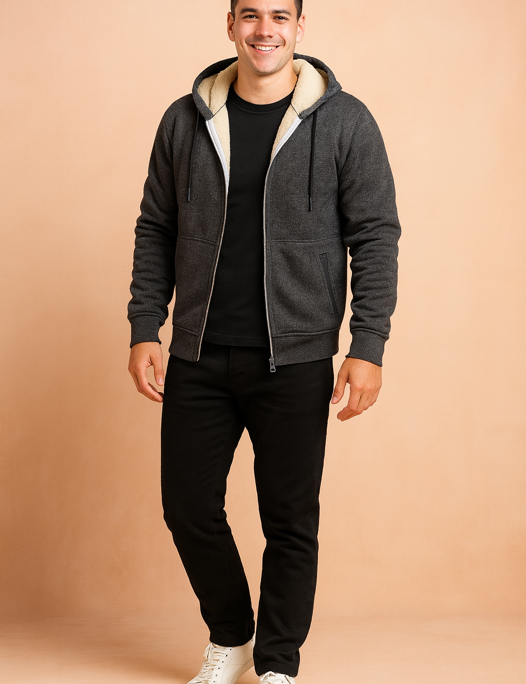 Charcoal gray zip-up hoodie with cream sherpa fleece lining, drawstring hood, and ribbed cuffs, styled with black trousers and white sneakers.