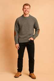 Gray knit crewneck sweater with brown suede elbow patches, ribbed cuffs and hem, styled with black trousers and tan suede lace-up shoes.