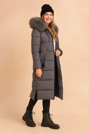 Women's long Gray puffer parka with faux fur hood, full front zipper, and side pockets, styled for winter warmth