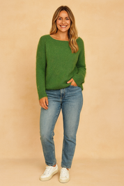 Soft-textured green crew-neck sweater paired with light-wash straight-leg jeans and white low-top sneakers.