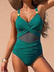 One-piece green swimsuit with crisscross bust, mesh midsection, and gold-tone strap accents