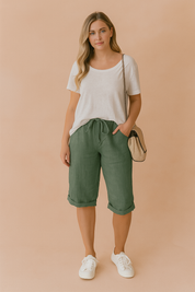 Casual green drawstring Bermuda shorts with rolled cuffs, paired with a relaxed-fit white T-shirt and white platform sneakers.