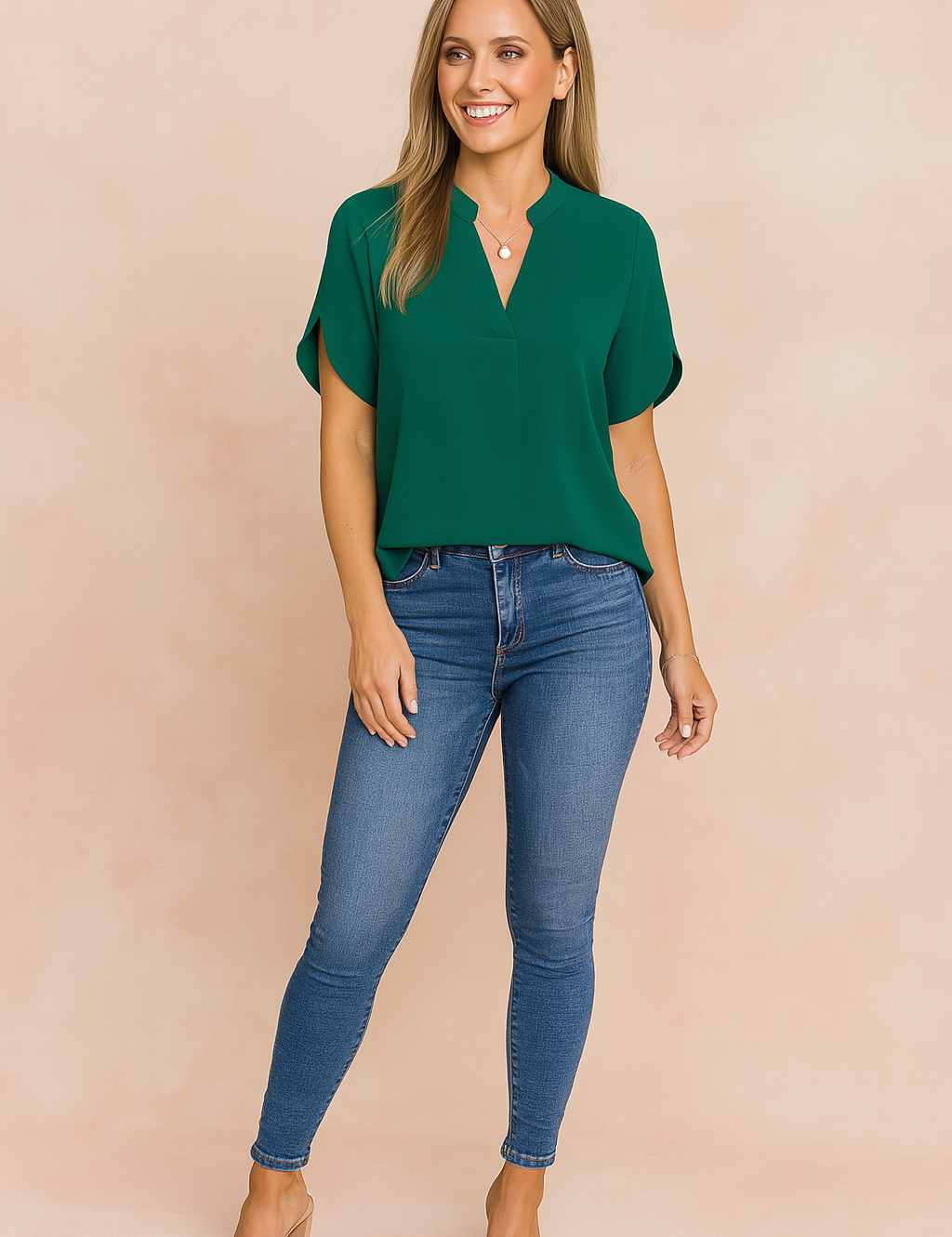 Women's casual outfit featuring a short-sleeve emerald green V-neck blouse paired with high-rise blue skinny jeans.