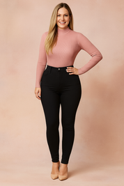 High-waisted black skinny jeans paired with a long-sleeve ribbed dusty pink turtleneck sweater, styled with nude pointed-toe heels.
