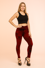 High-waisted red denim-print leggings with distressed details and a sleek skinny fit, styled with black strappy high heels.
