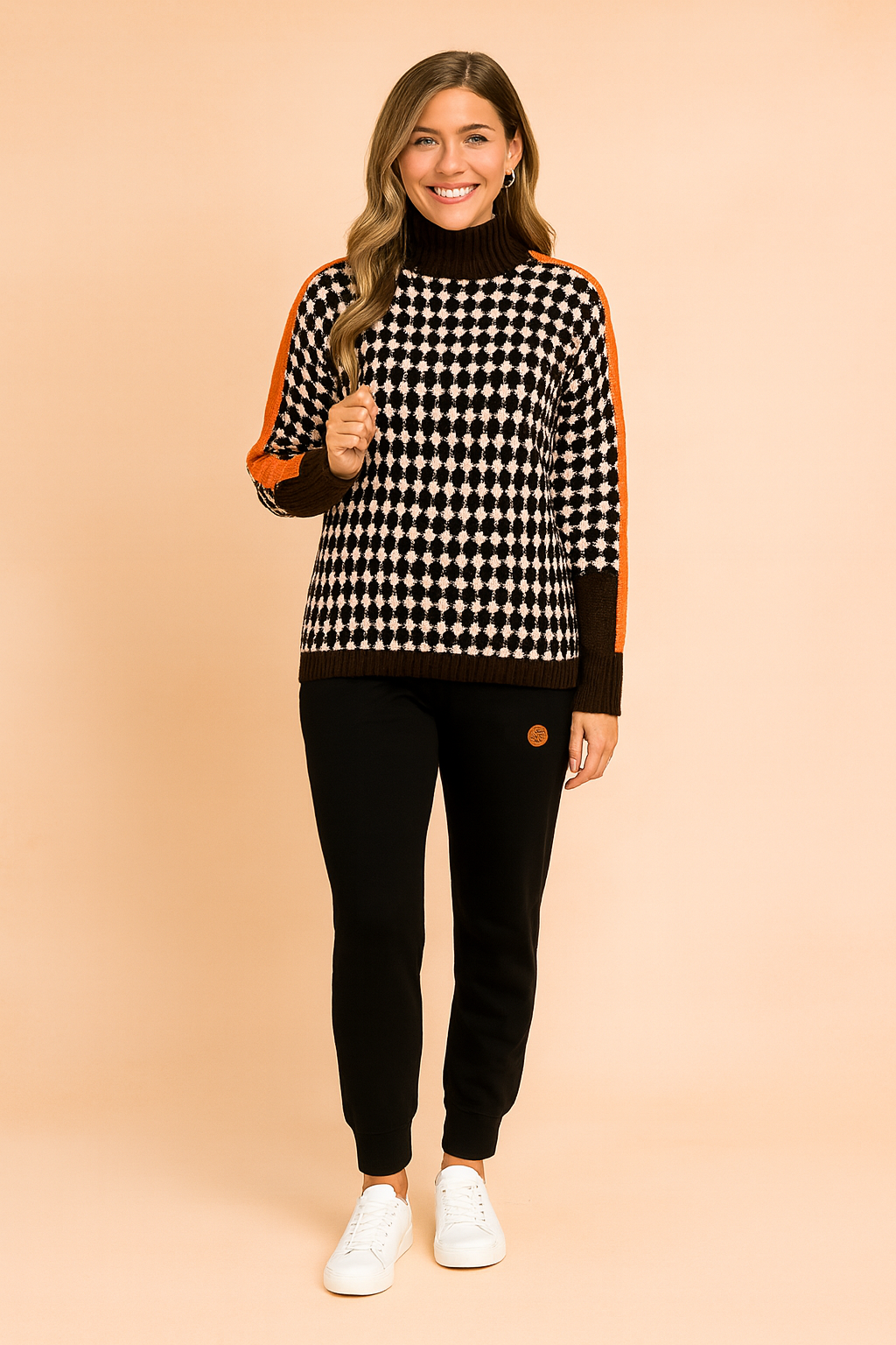 Oversized houndstooth turtleneck sweater with bold orange stripe detailing on sleeves, paired with black jogger pants and white sneakers.