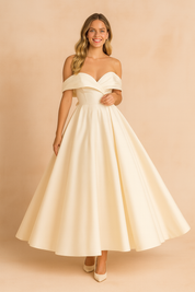 Elegant off-shoulder ivory evening gown with a fitted bodice, pleated flowing skirt, and structured neckline for a timeless formal look.