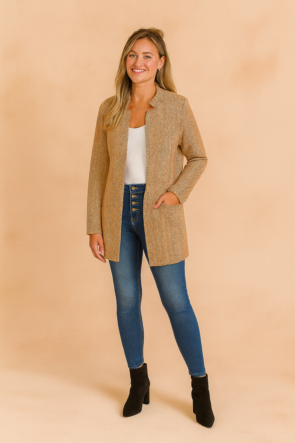 Women's long open-front beige woven jacket with subtle herringbone texture, paired with high-waist buttoned blue skinny jeans and a classic white scoop neck top.