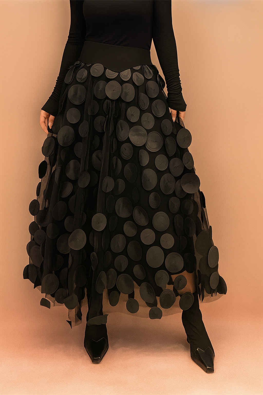 Laura – Elegant black summer skirt featuring large circular appliqués, styled with a fitted black top and boots, perfect for bold fashion statements in a chic editorial setting.