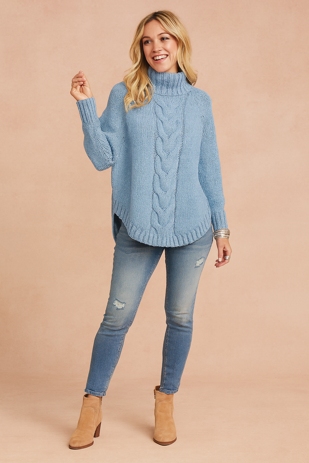 Light blue cable-knit high-neck sweater with ribbed cuffs and hem, paired with distressed light-wash skinny jeans and tan suede ankle boots.