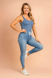 High-waisted light blue jeggings with a denim-look print, distressed faded detailing, elastic waistband with white drawstring tie, and paired with white sneakers.