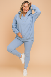 Light blue textured hoodie and matching fitted leggings set with button-front detail, styled with white sneakers for a casual and sporty look.