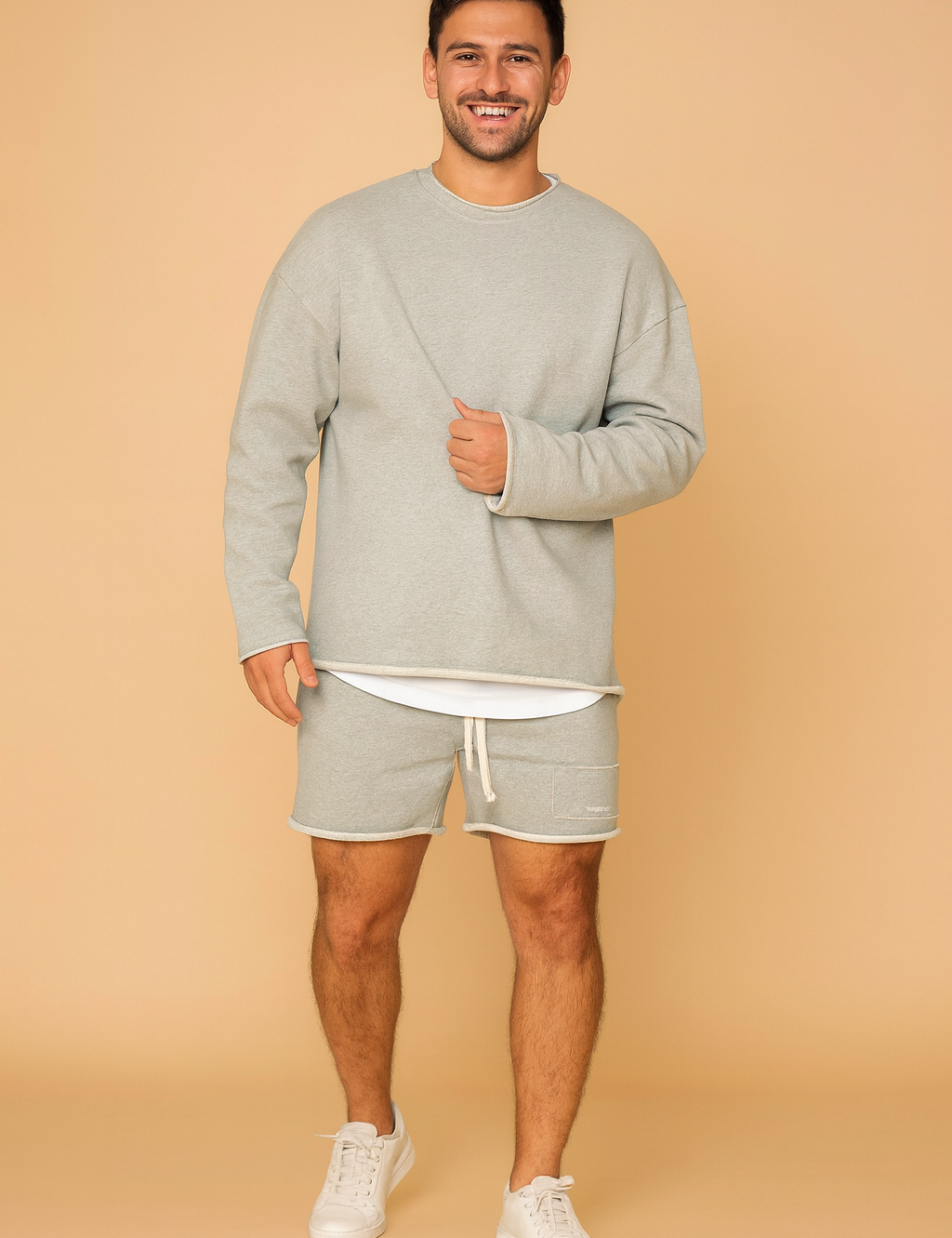 Light grey men’s sweatshirt and shorts lounge set with a relaxed oversized fit, ribbed cuffs, layered hem detail, and soft fabric texture for everyday casual wear.
