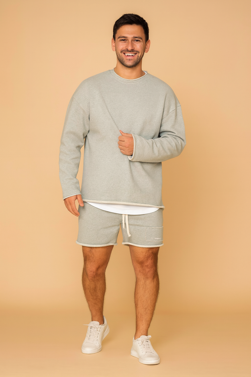 Light grey men’s sweatshirt and shorts lounge set with a relaxed oversized fit, ribbed cuffs, layered hem detail, and soft fabric texture for everyday casual wear.
