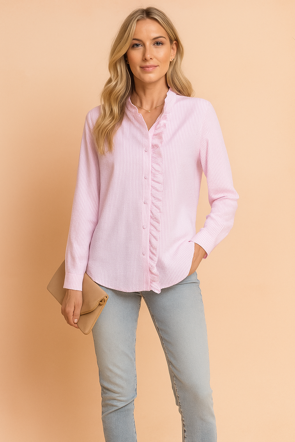 Light pink seersucker blouse with vertical stripes and ruffled button placket, styled for modern casual fashion with long sleeves and a soft, breathable texture.