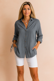 Stylish woman wearing a button up blouse with rolled sleeves paired with white shorts