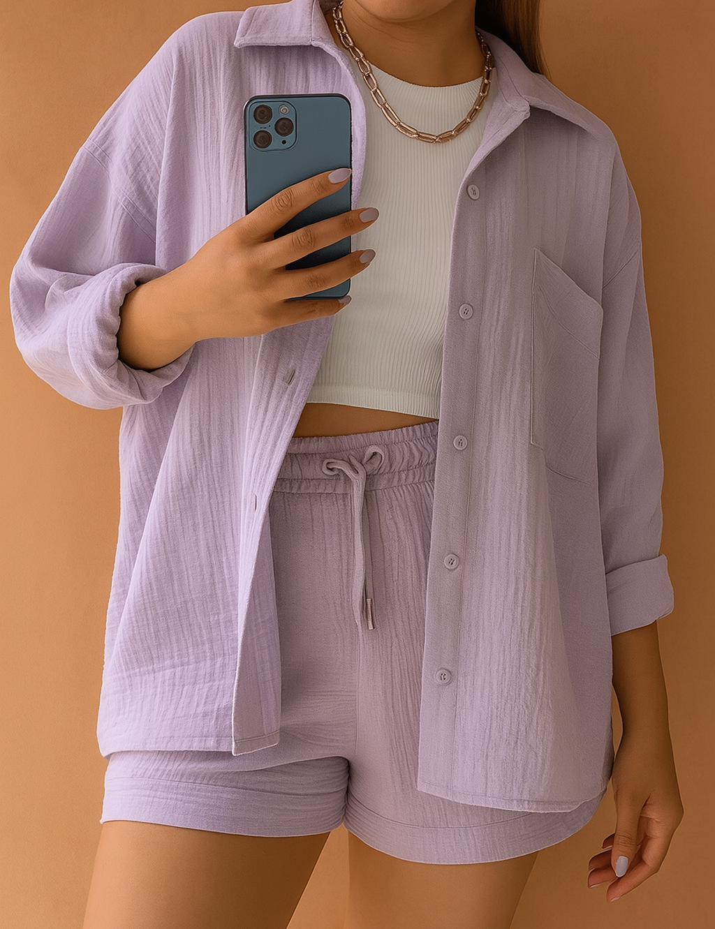 Crinkled lilac loungewear co-ord set featuring a button-up oversized shirt and high-waisted drawstring shorts, styled with a white ribbed crop top and chain necklace.
