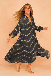 Confident European woman in a loose black and beige tie-dye maxi shirt dress with buttons.