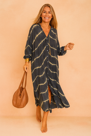 Confident European woman in a loose black and beige tie-dye maxi shirt dress with buttons.